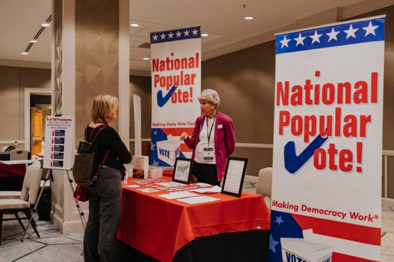 Women talking at a conference booth