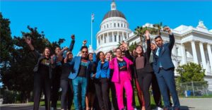 Dora and LWVC partners pose in front of Capitol building, fists up in the air